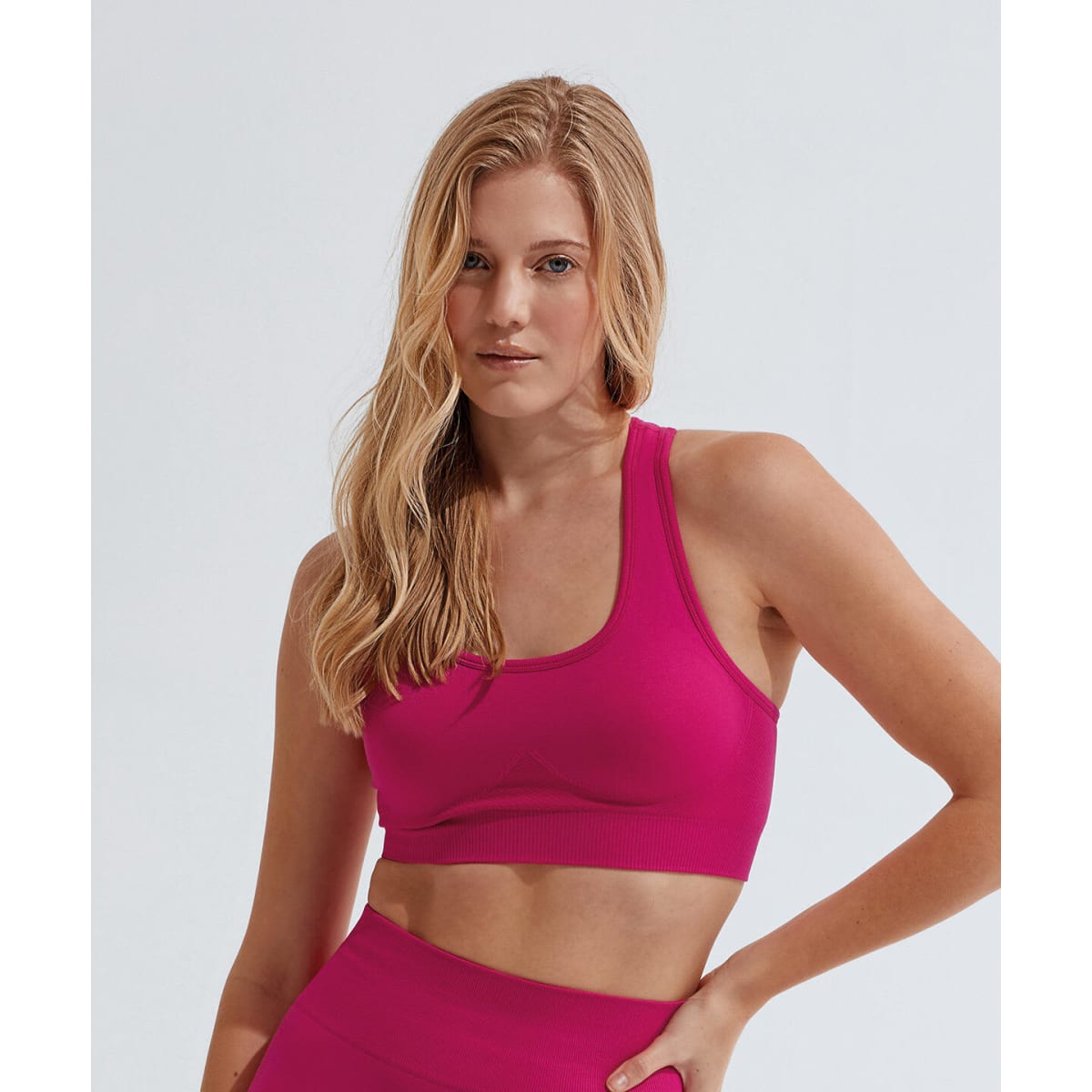 A pink seamless 3D fit sport sculpt bra displayed on a model against a plain background.