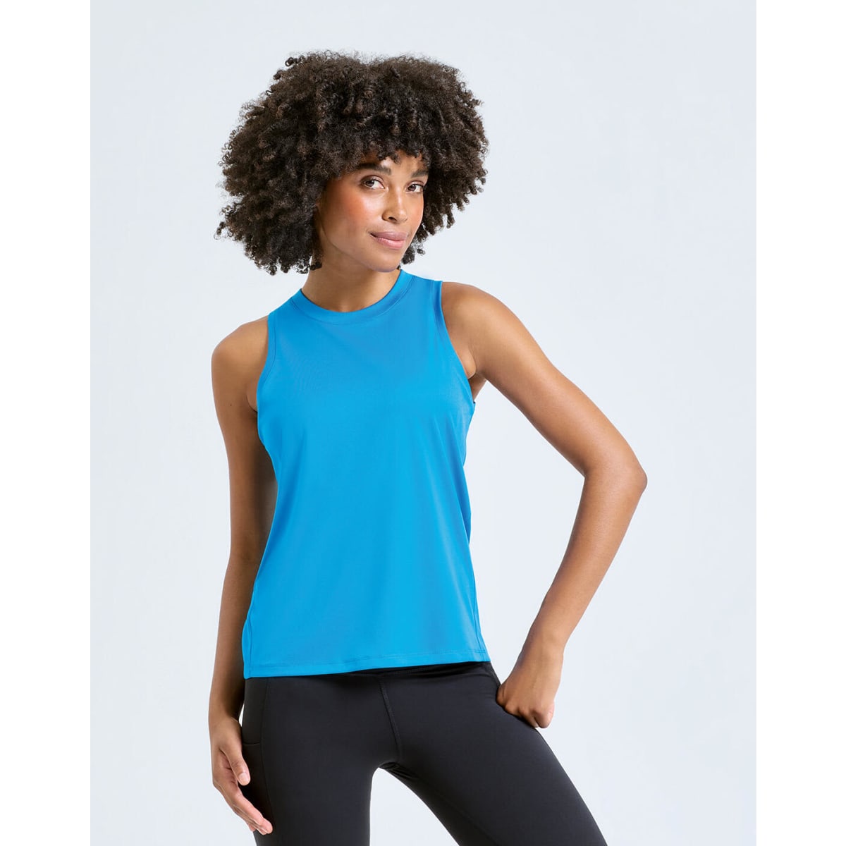 A tank top in vibrant blue featuring a sleek design, displayed by a model with curly hair. It has a logo on the front.