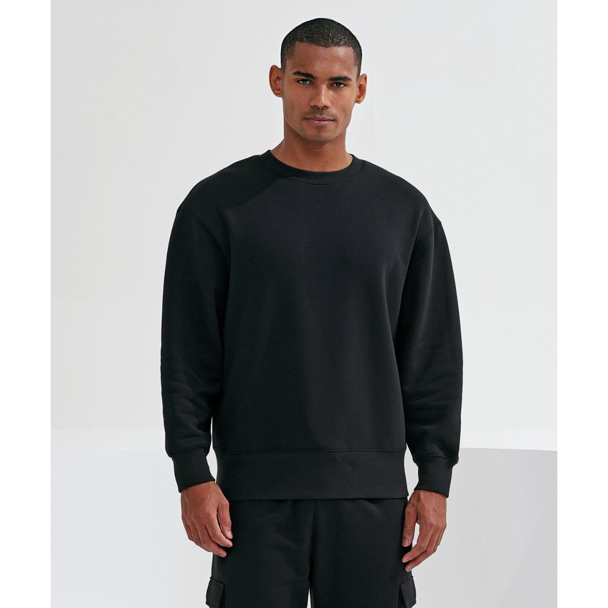 A unisex sweatshirt in black, featuring a relaxed fit and a simple design. It has a logo on the sleeve.