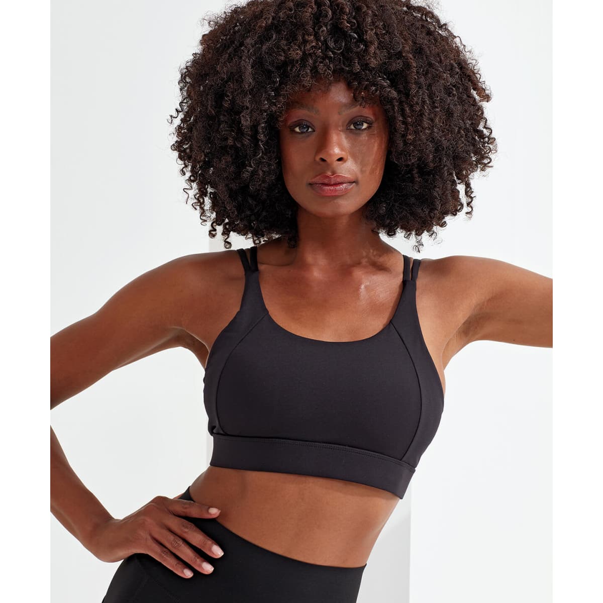 A black sports bra with a crossback design, featuring adjustable straps and a fitted silhouette.