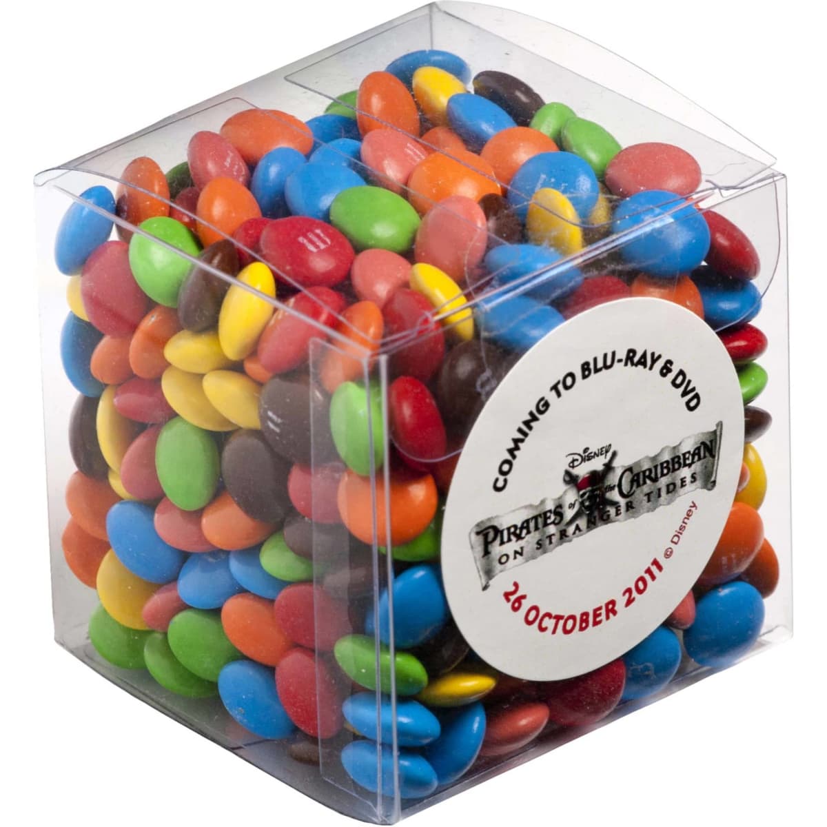 A clear cube filled with colourful chocolate-coated candy, including red, blue, yellow, green, and brown M&Ms.