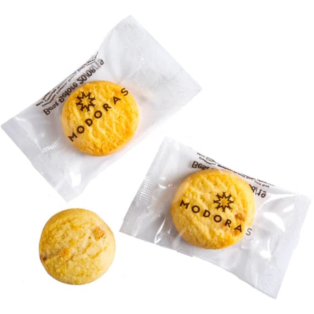 Three bite-sized biscuits in clear packaging, featuring a logo. Biscuits are golden yellow with a textured surface.