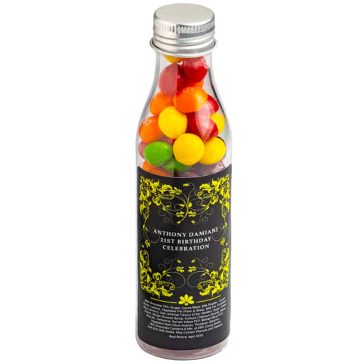 A drink bottle filled with colourful Skittles, featuring a metallic silver cap and decorative black and yellow label.
