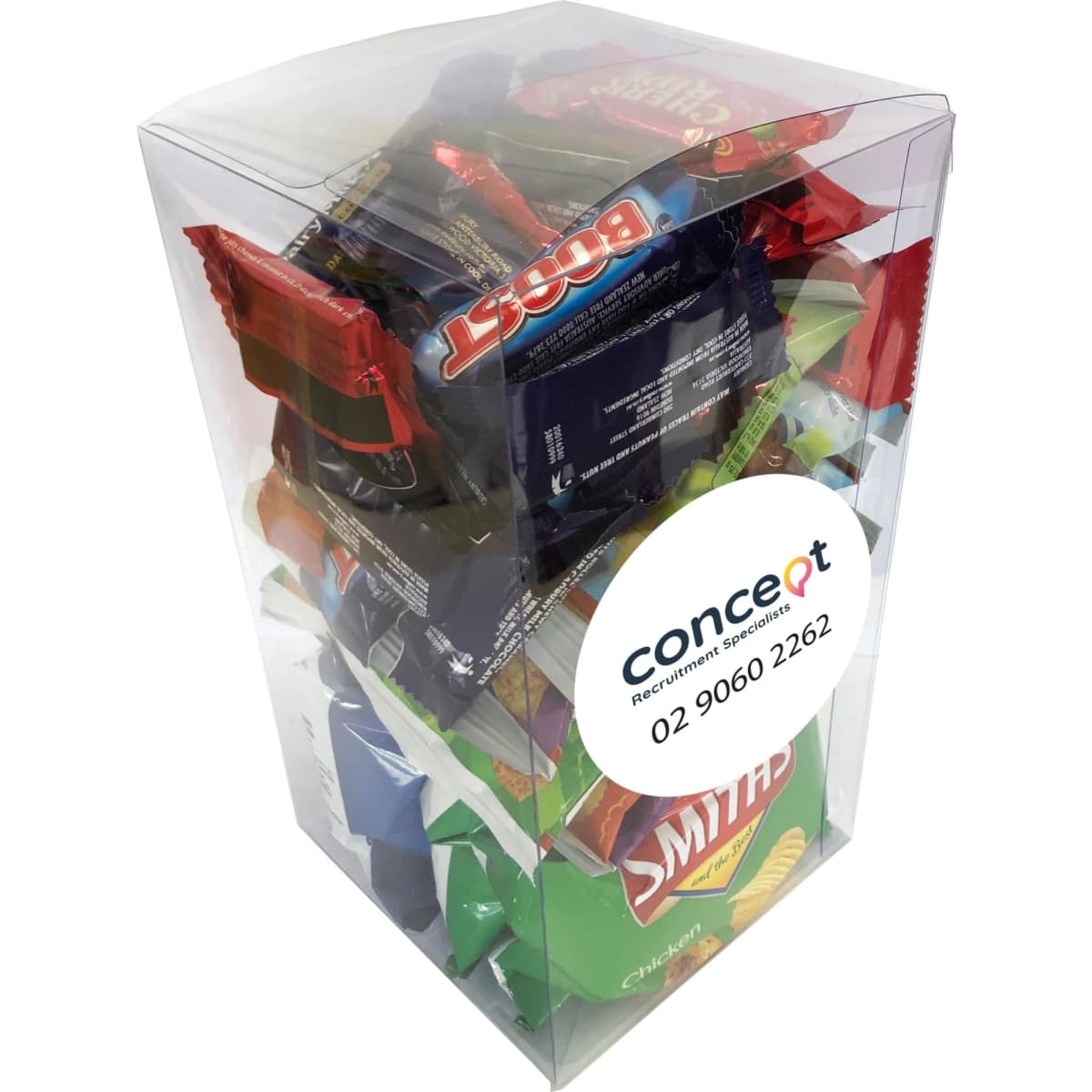 A clear PVC gift box filled with various confectionery, including chocolate bars and crisps, featuring vibrant colours.