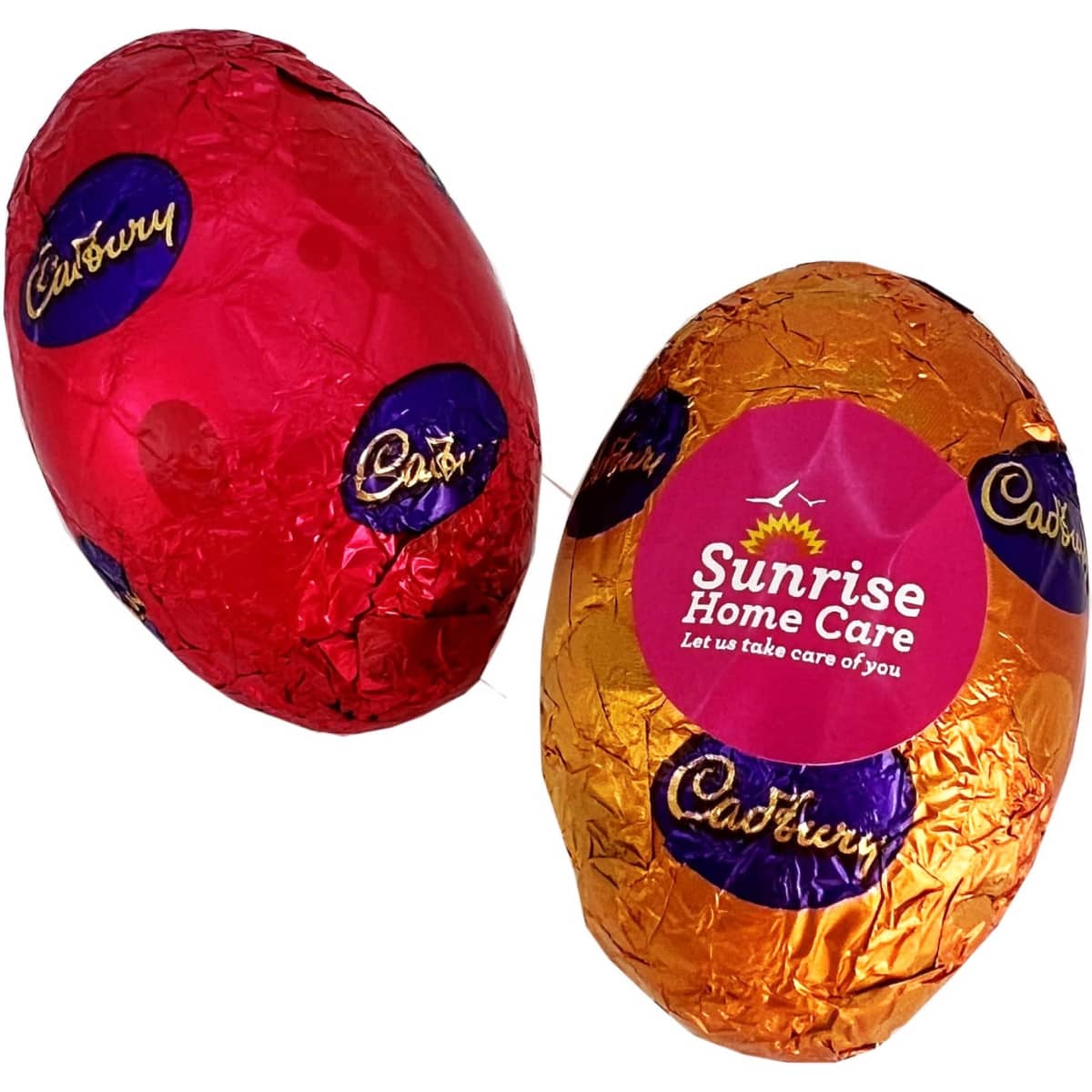 Two wrapped hollow chocolate Easter eggs in red and orange foil, featuring branding on one egg.