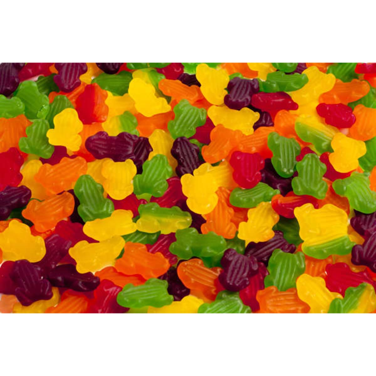 A variety of gummy lollies shaped like frogs in vibrant colours including green, yellow, red, and purple.