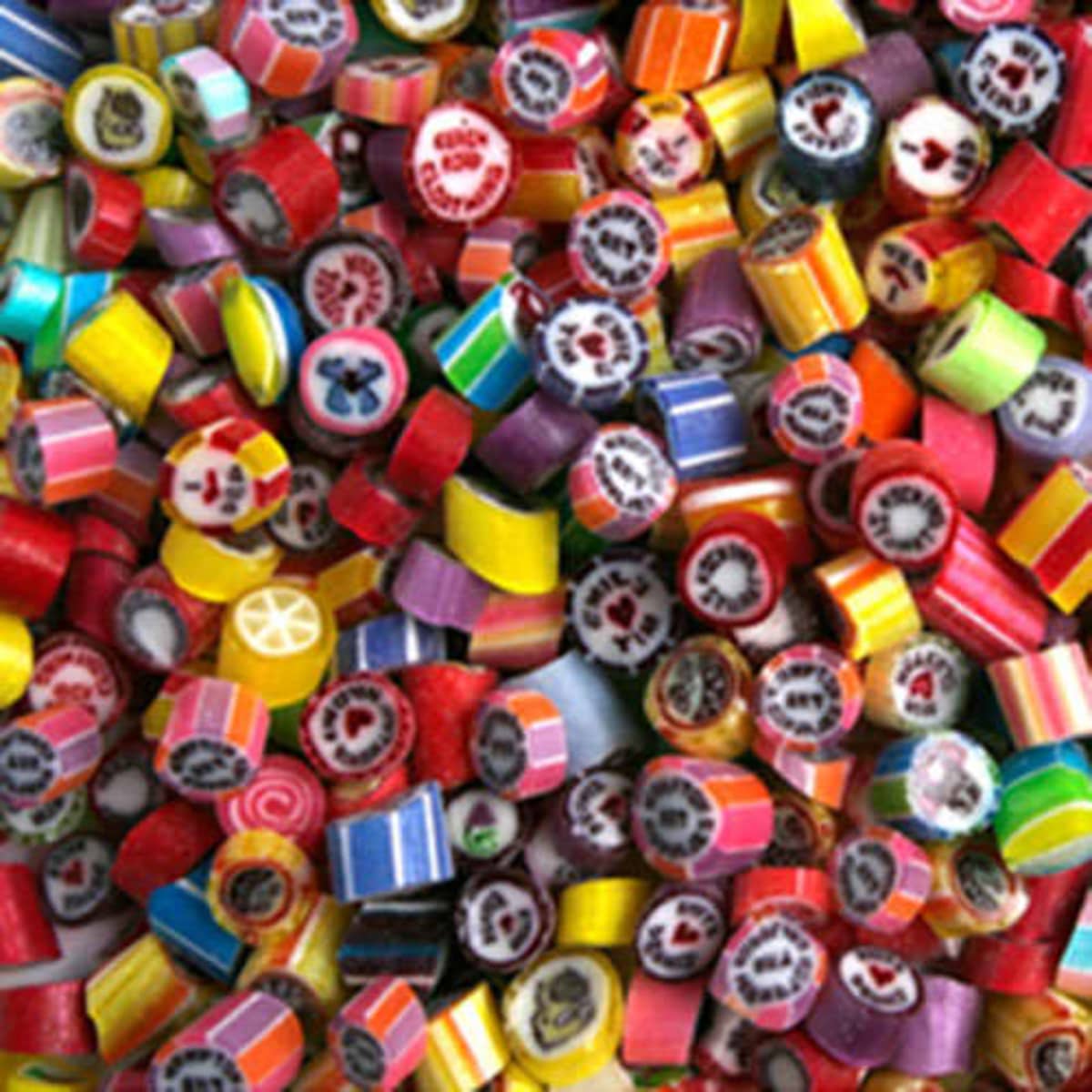 A vibrant assortment of personalised rock candy pieces in various colours and designs, with a mix of patterns.