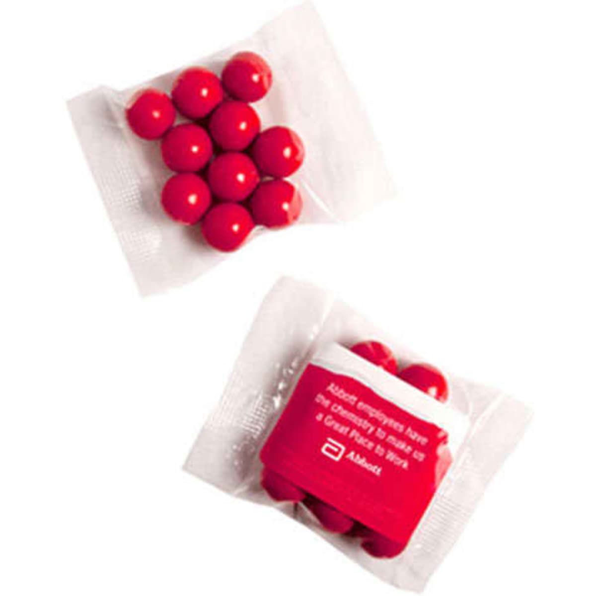 A pack containing round orange chocolate drops, featuring a clear wrapper and a white label with branding.