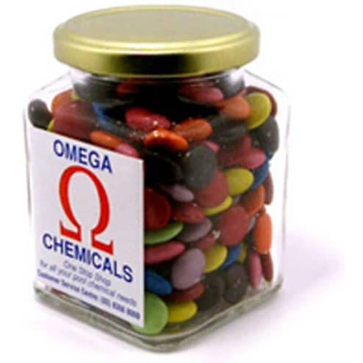 A glass square jar filled with colourful choc beans, featuring a gold lid and a logo on the front.