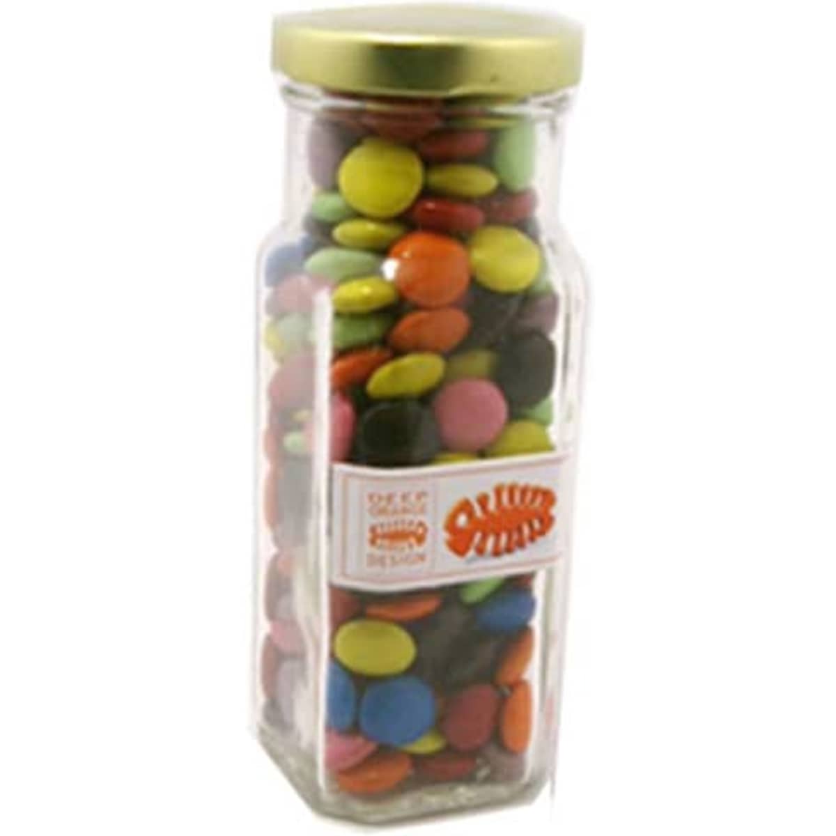 A glass tall jar filled with colourful choc beans, featuring a gold lid and a branding label.