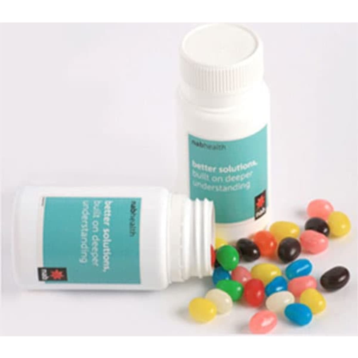 A pill jar filled with colourful jelly beans in various shades, alongside an open jar with beans spilling out.