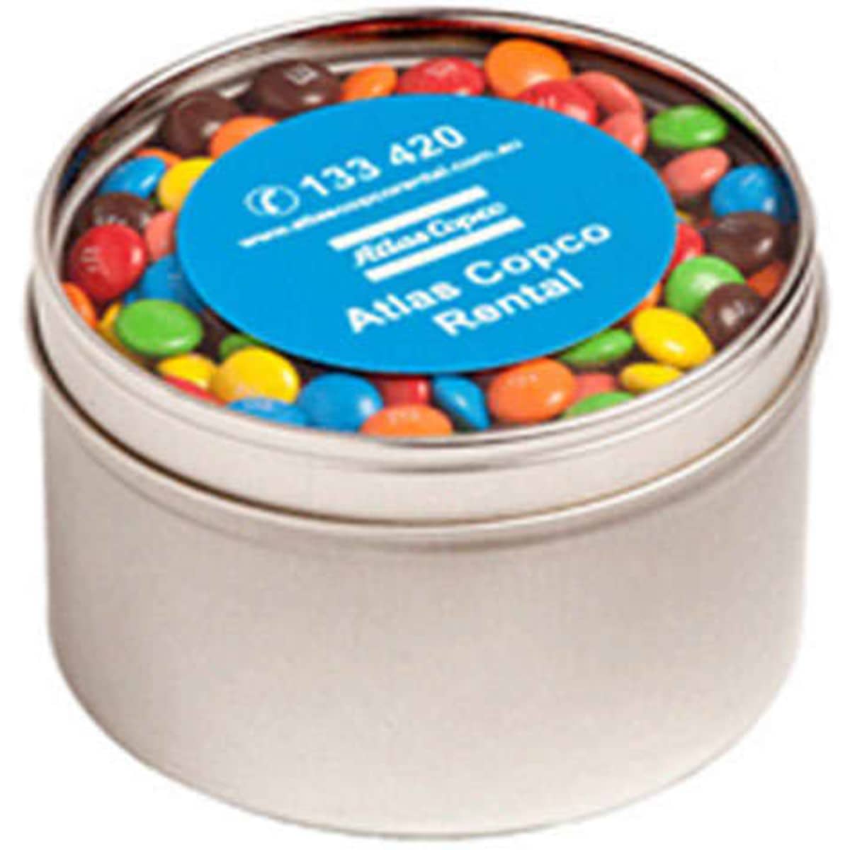 A small round tin filled with colourful M&Ms, featuring a blue label and a silver finish.