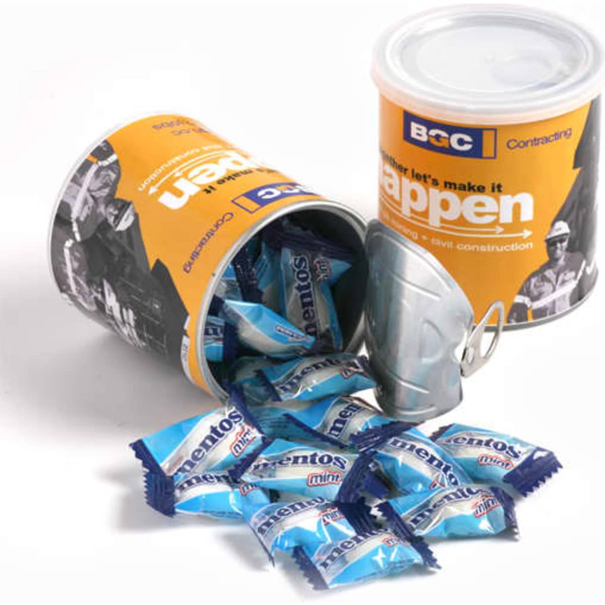 A cylindrical container in orange and white, filled with blue Mentos mints, with some mints spilling out.