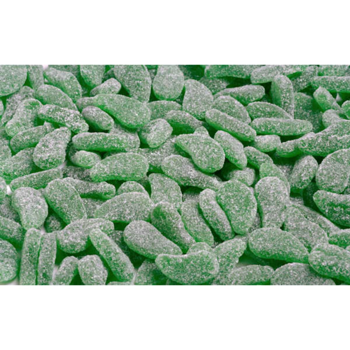 A close-up of green spearmint-flavoured gummy sweets, dusted with sugar, presented in an enticing pile.