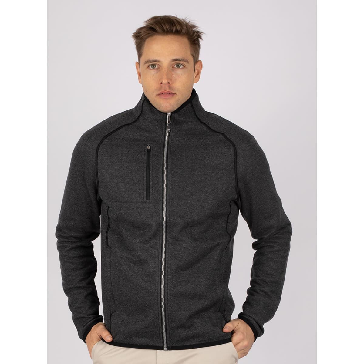 A men's full zip jacket in dark grey, featuring a sleek design and a zippered chest pocket. It has a logo.
