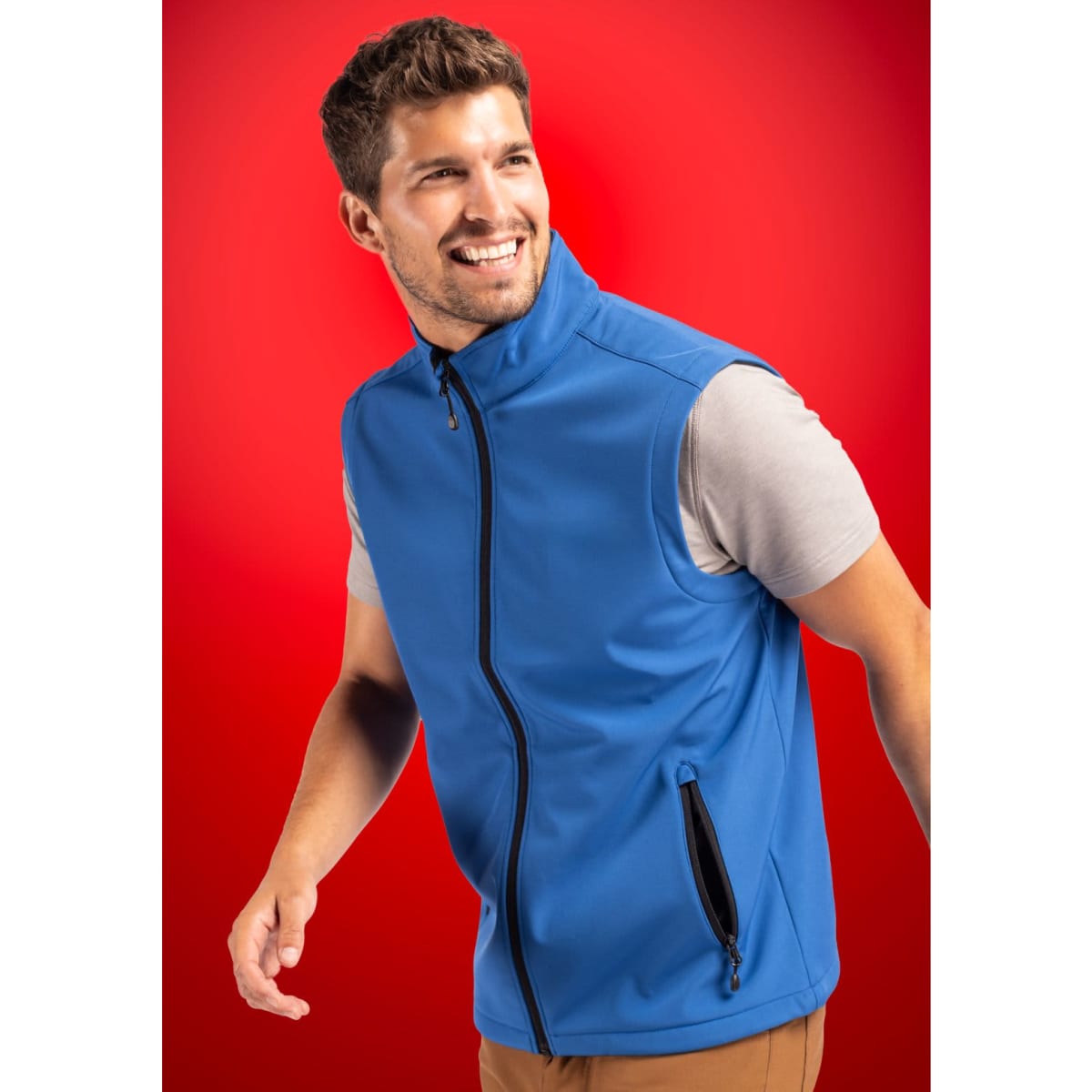 Men’s Tempo Eco Stretch Vest in blue, featuring a full zip and side zip pockets, against a red background.