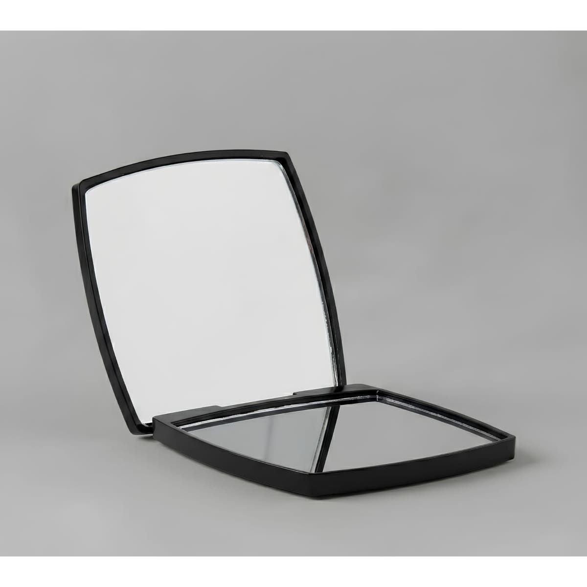 A compact mirror with a sleek black exterior, featuring two reflective surfaces inside. It has branding visible.