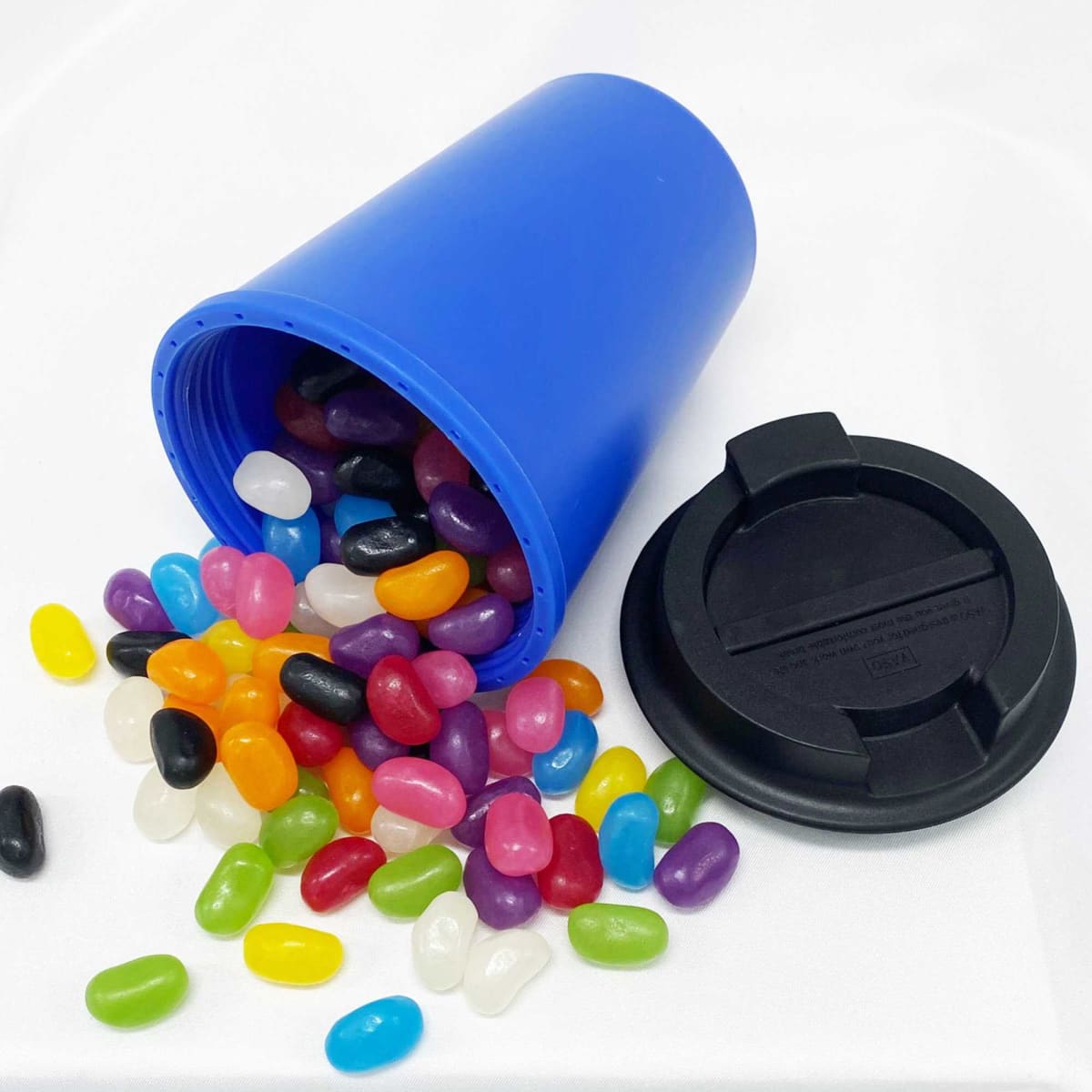 A drink bottle in blue with a black lid, filled with vibrant assorted jelly beans spilling out.