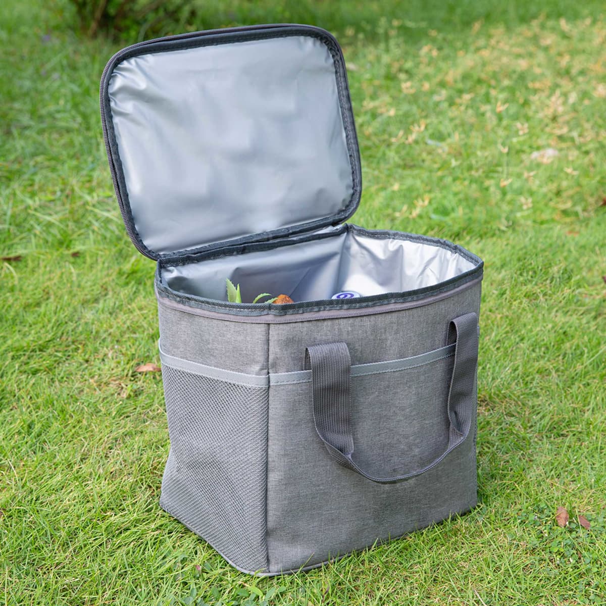 A grey nylon cooler bag with an open lid, featuring a silver interior and side pockets.