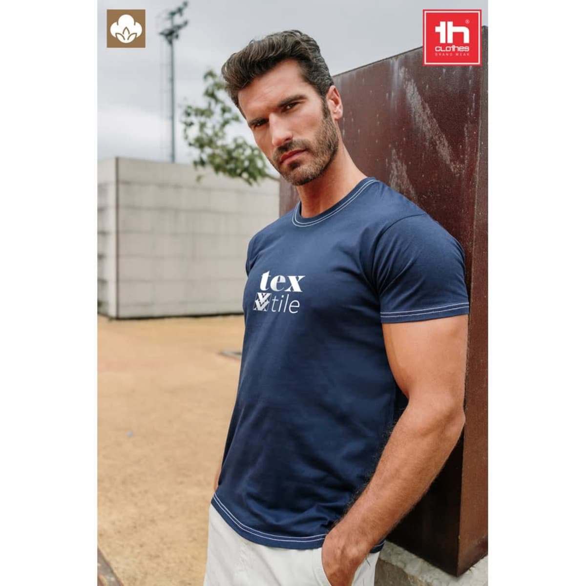 A navy blue 100% cotton t-shirt with a logo, featuring a fitted cut and short sleeves.