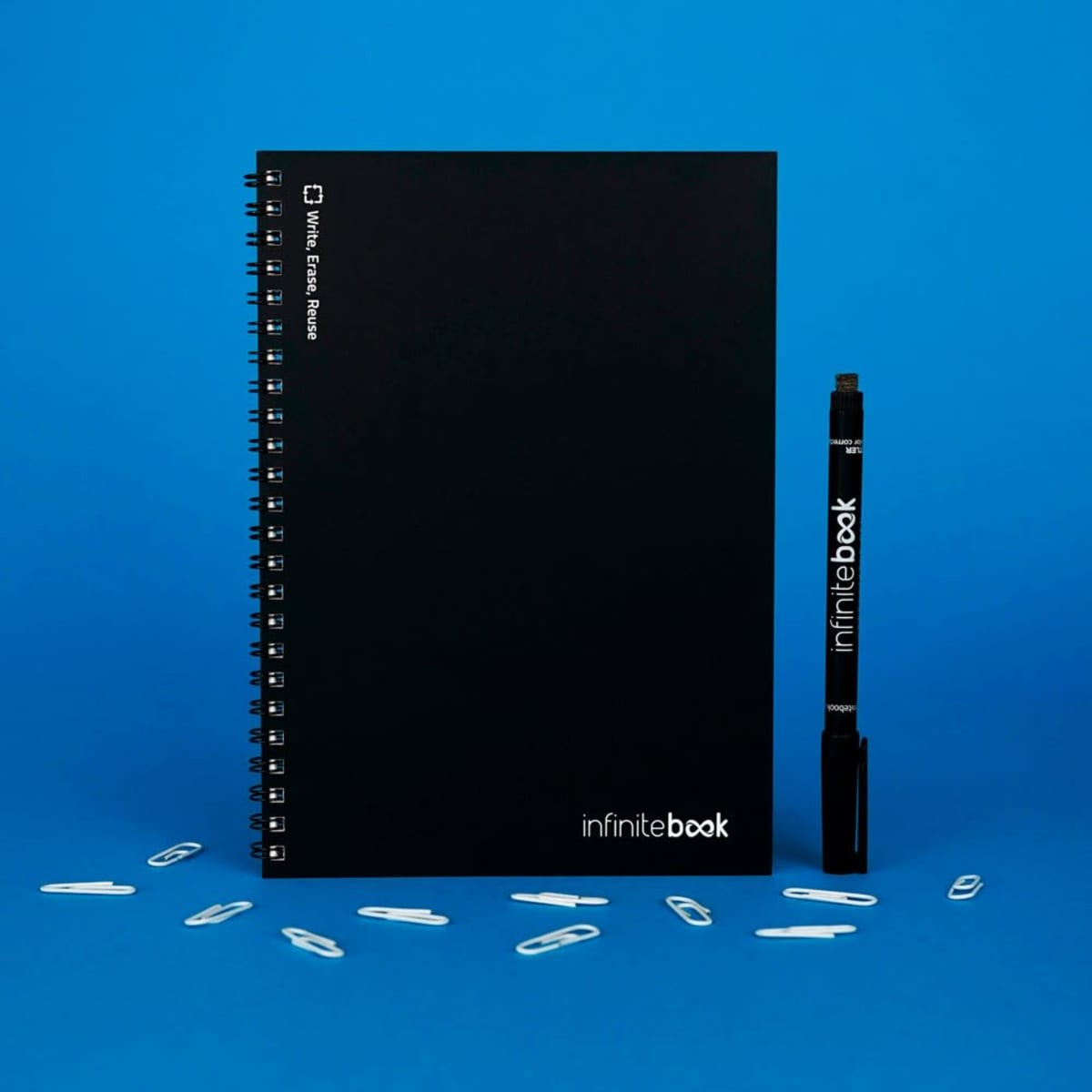 A black A5 Infinitebook with a flexible cover, featuring whiteboard pages and a black marker beside it.