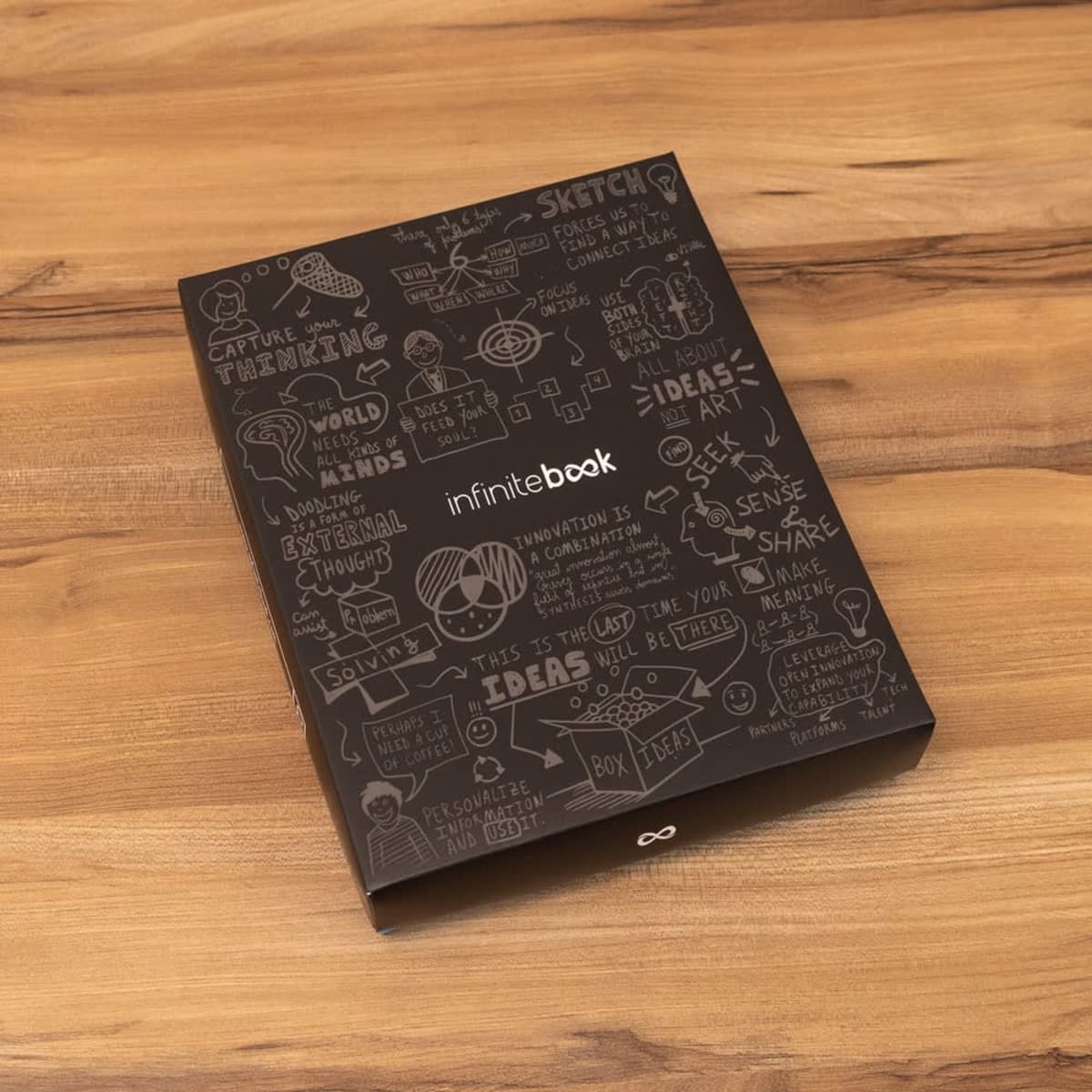 A black Infinitebook A5 planner with a hard cover featuring artistic designs and a logo.
