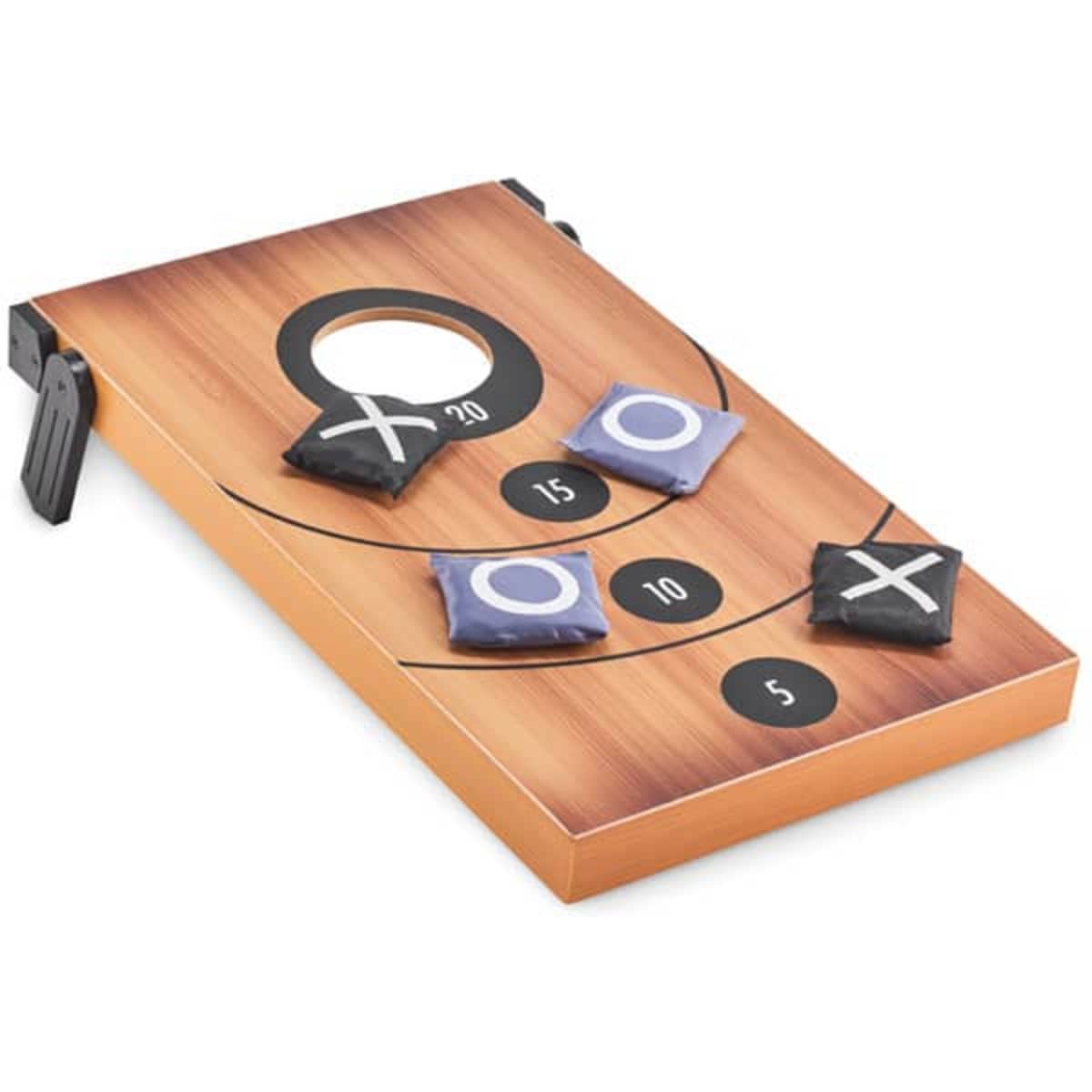 A bean bag toss game on a wooden board, featuring holes with varying point values and black and white bags for playing.