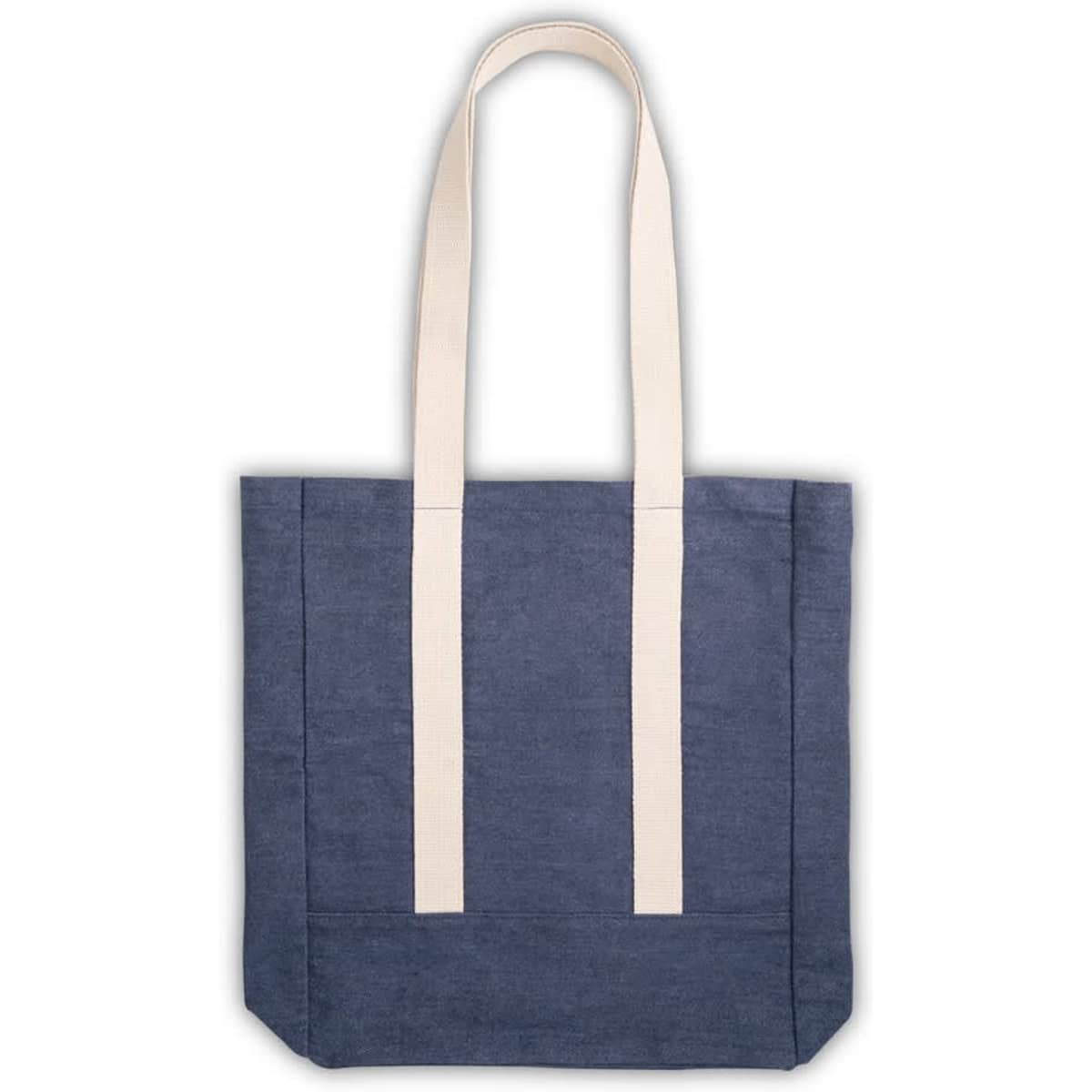 A denim tote bag in dark blue with cream coloured straps and a logo.