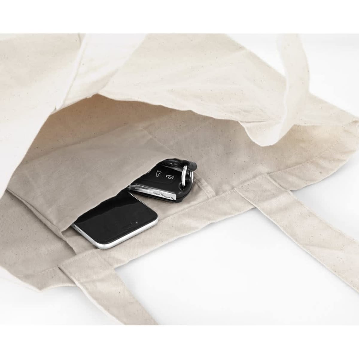 A light beige cotton tote bag with a pocket containing a phone and keys inside. The bag has a logo.