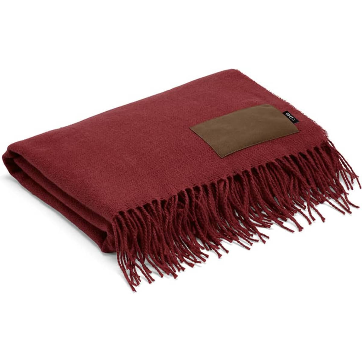 A burgundy blanket with fringed edges and a brown customisable patch. It has a simple and elegant design.