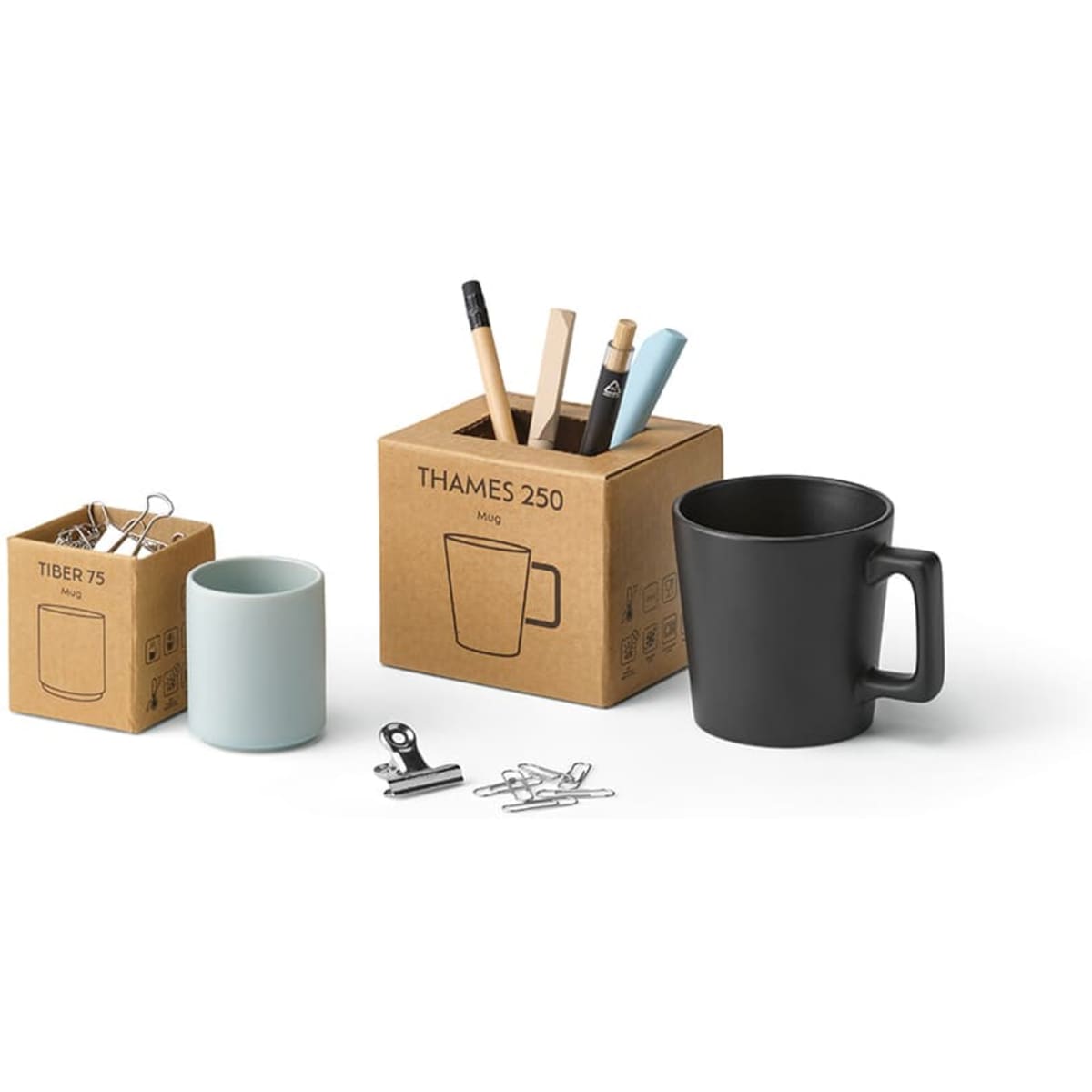A matte black ceramic mug alongside a box with stationery items, including two smaller containers in various colours.
