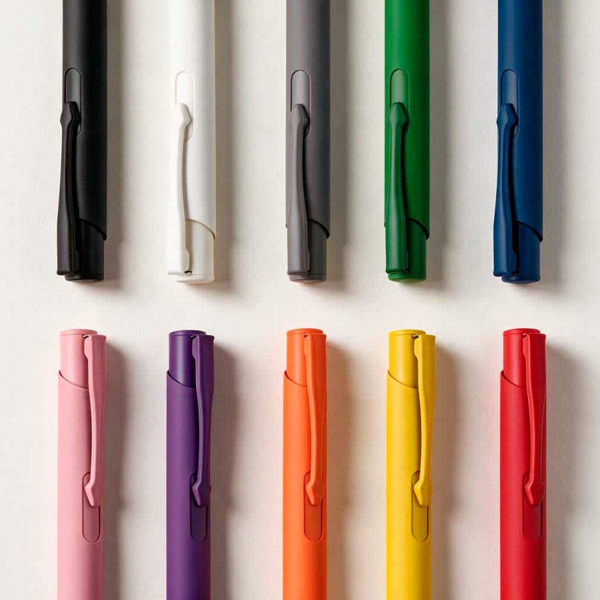 A collection of pens in various colours including black, white, grey, green, blue, pink, purple, orange, and red, featuring clips.