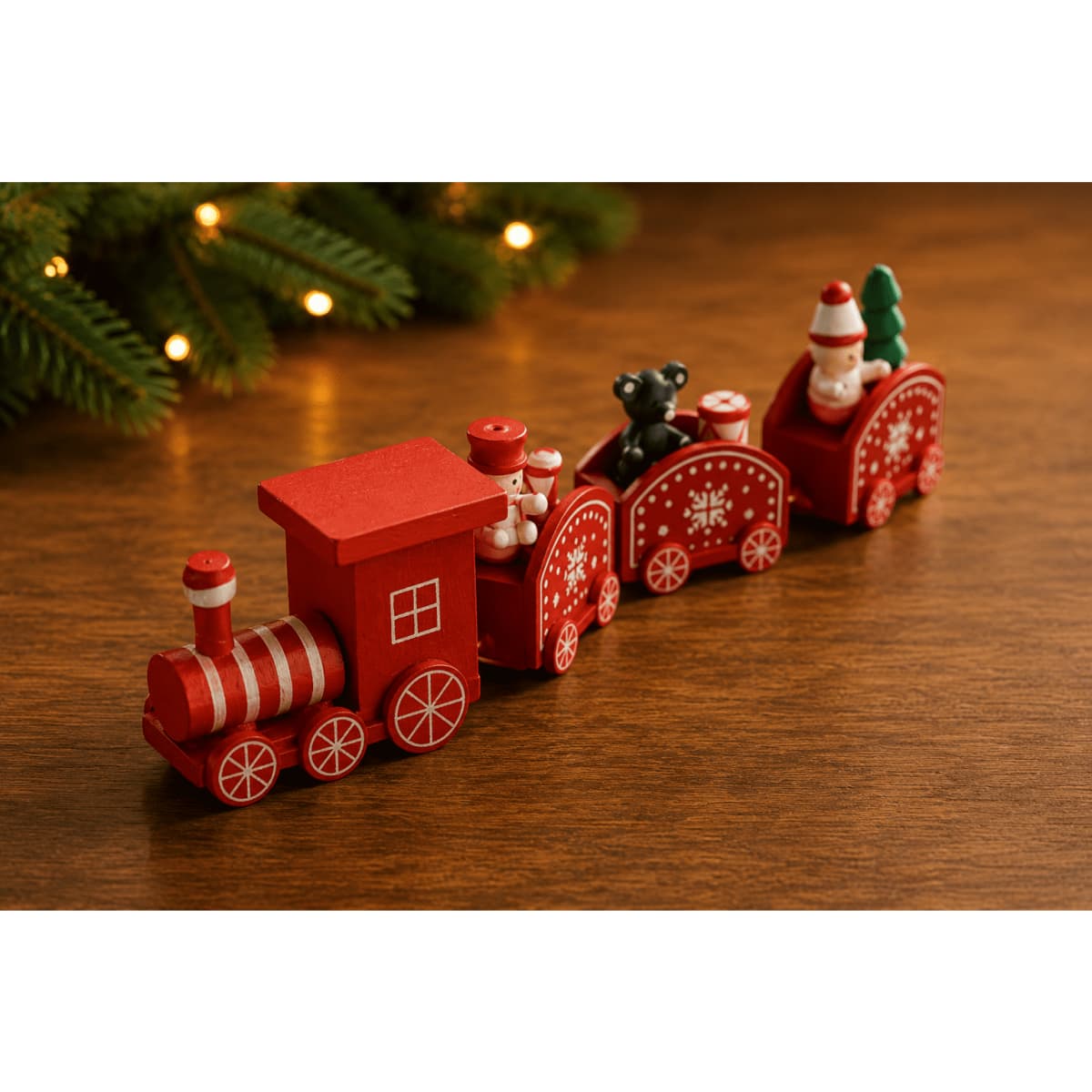 A decorative red wooden train featuring festive characters, set against a wooden background with green foliage.