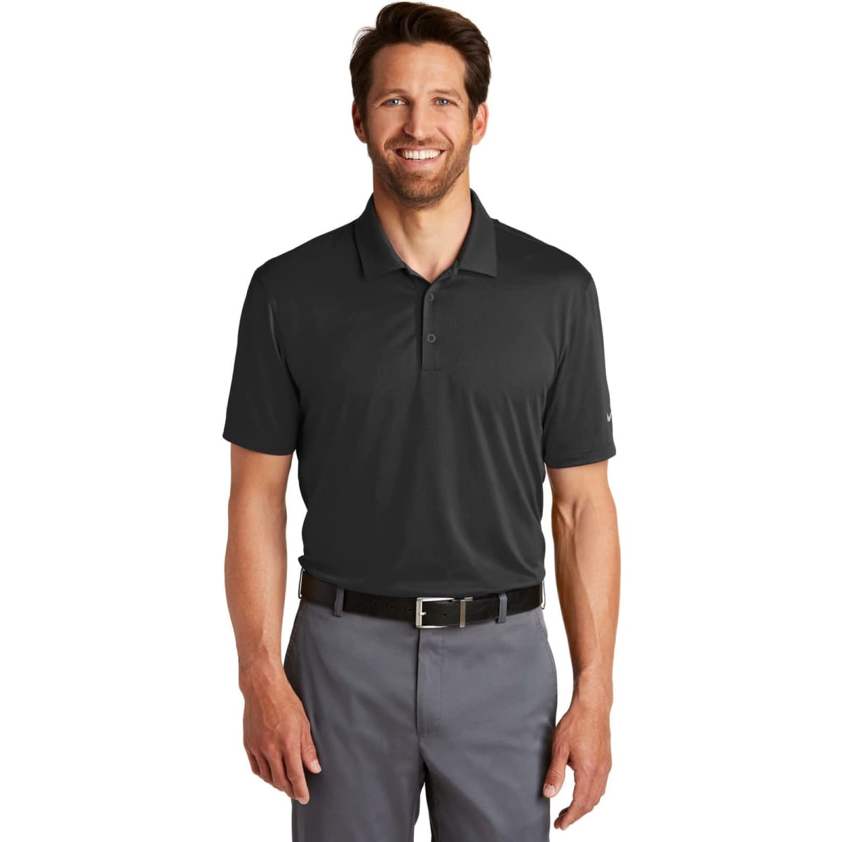 A man wearing a black Nike Dri-FIT Legacy Polo shirt, paired with grey trousers and a belt. The shirt features a logo.