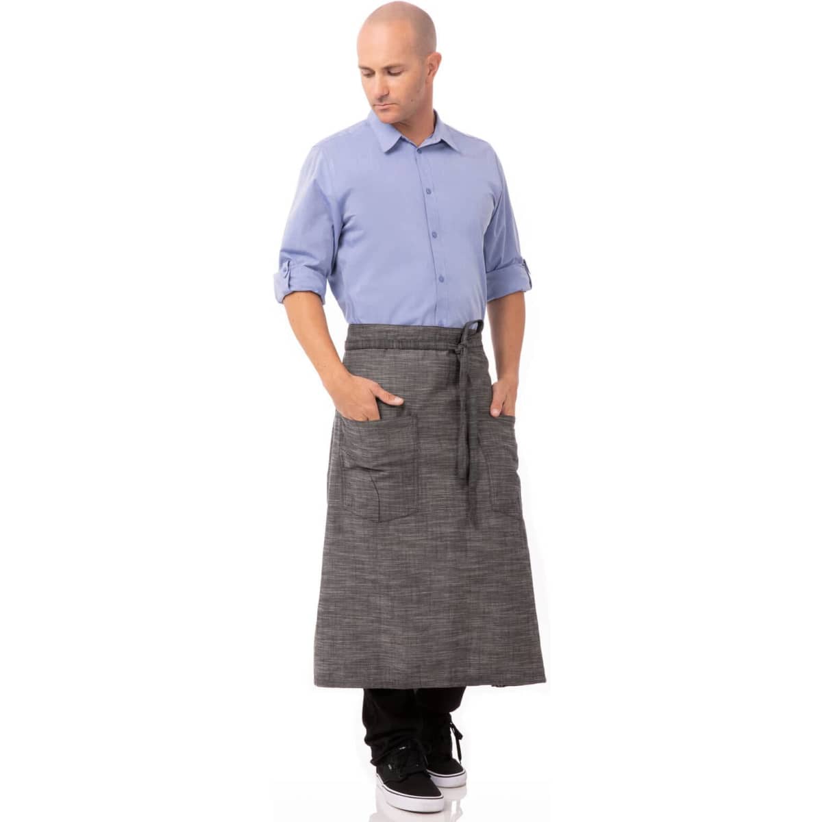 A man wearing a grey bistro apron over black pants, featuring pockets and tied at the waist.