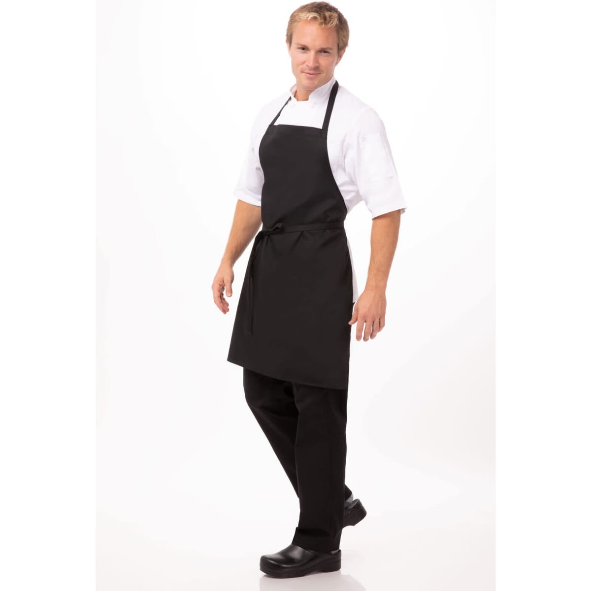 A black bib apron worn by a person, featuring adjustable straps and a functional design. The individual is standing confidently.