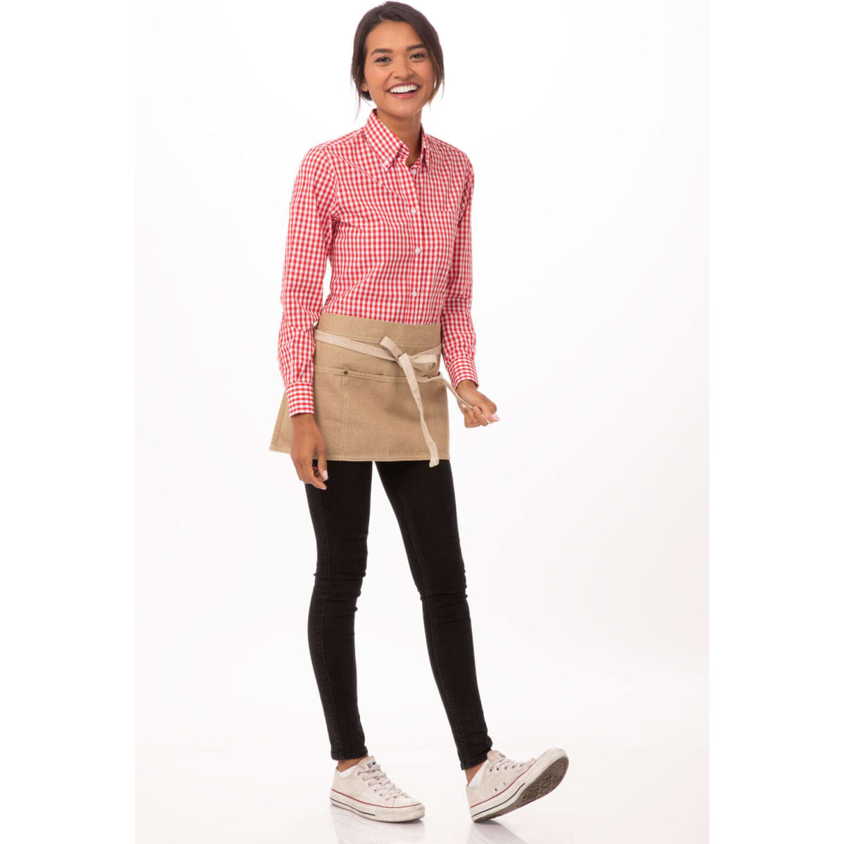 A woman wearing a checked red shirt and black pants models a beige waist apron with a tie. The apron features a logo.