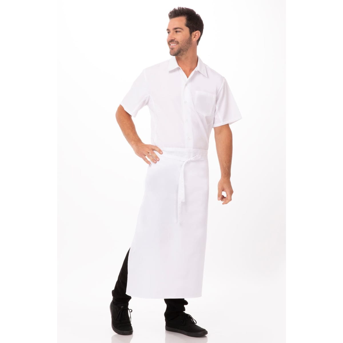 A white bar apron worn by a smiling man in a short-sleeve shirt, standing with one hand on his hip.