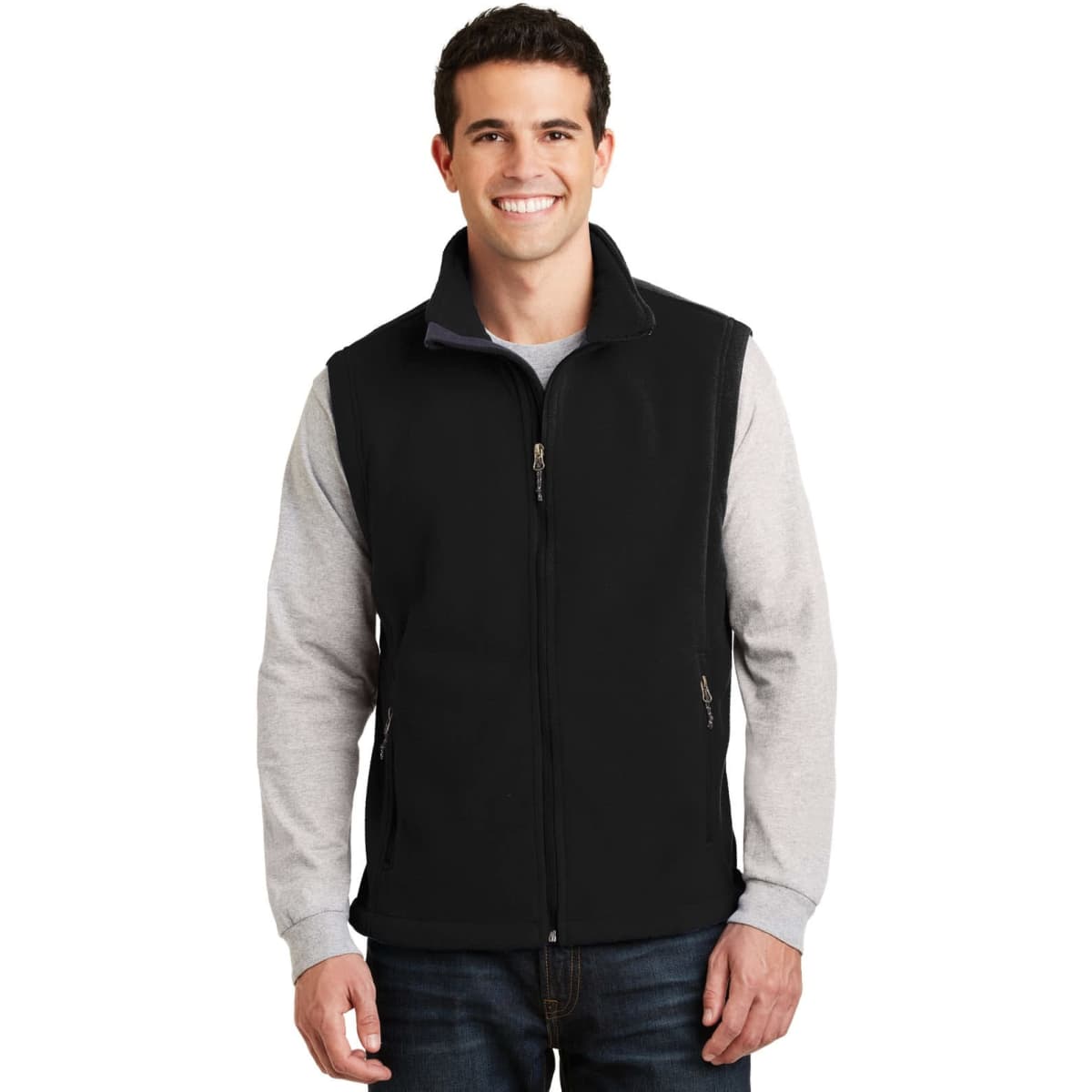 A man models a black fleece vest over a grey long-sleeve shirt, featuring a zippered front and side pockets. A logo is visible.