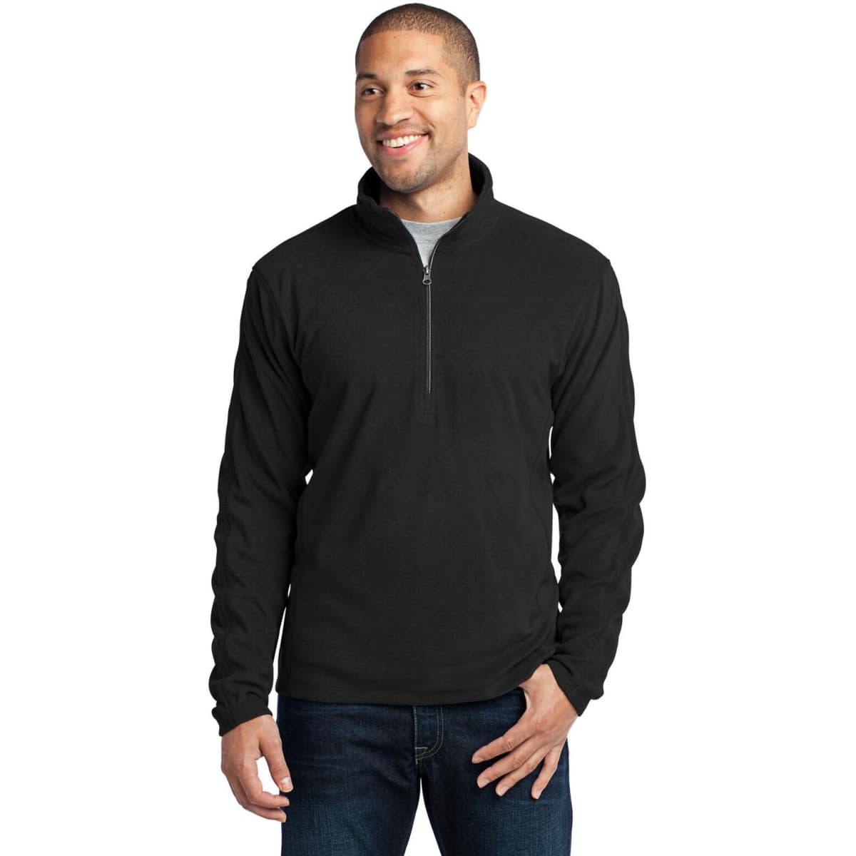 A man smiles while wearing a black microfleece 1/2-zip pullover. The garment features a soft texture and a zippered neck.