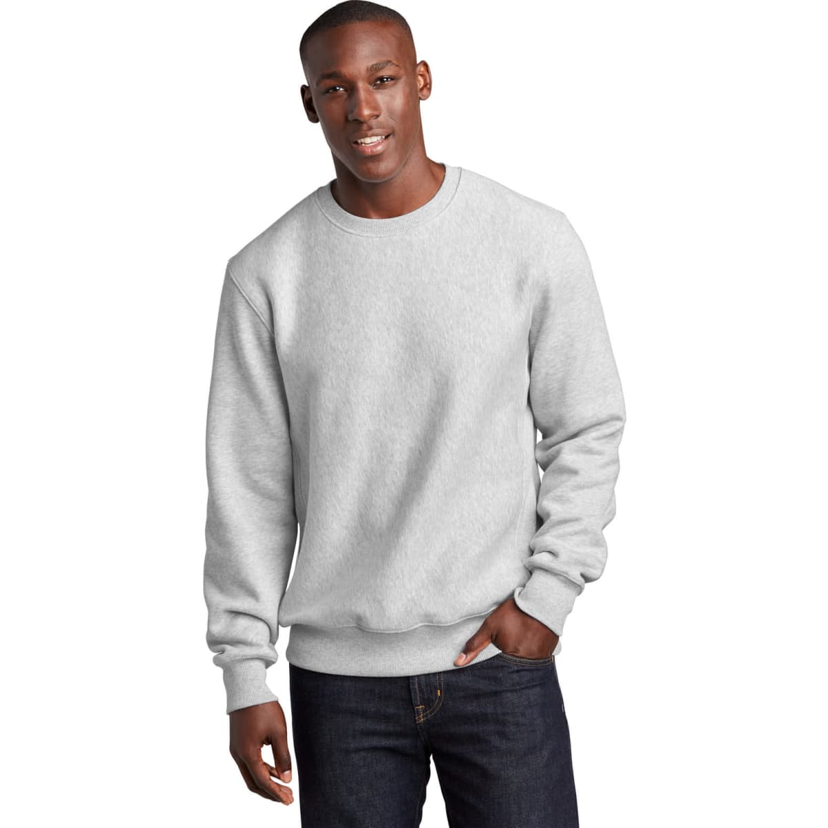 A grey crewneck sweatshirt is worn by a model, featuring long sleeves and a relaxed fit. It has a logo on the chest.