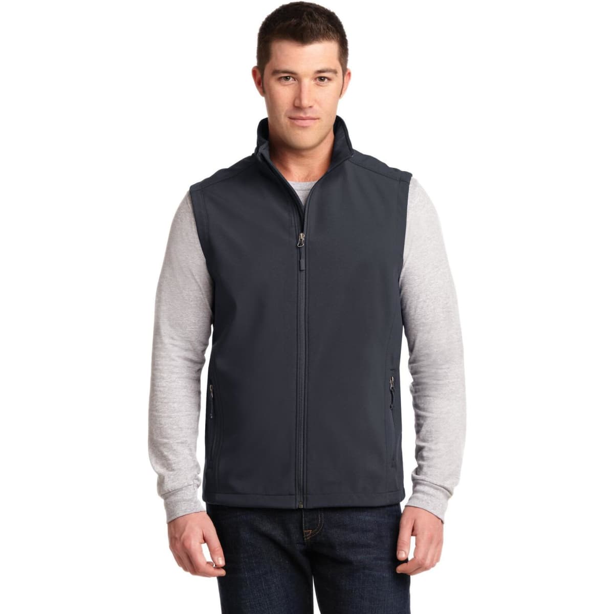 A man wearing a dark navy soft shell vest with a zip front and side pockets, paired with a grey long-sleeve shirt.