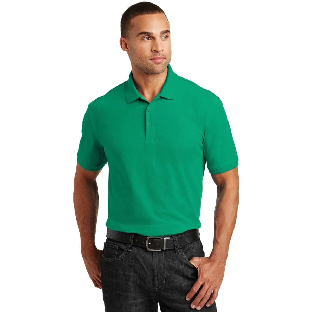 A green polo shirt with short sleeves, featuring a collar and a logo. The model is wearing it with dark jeans.