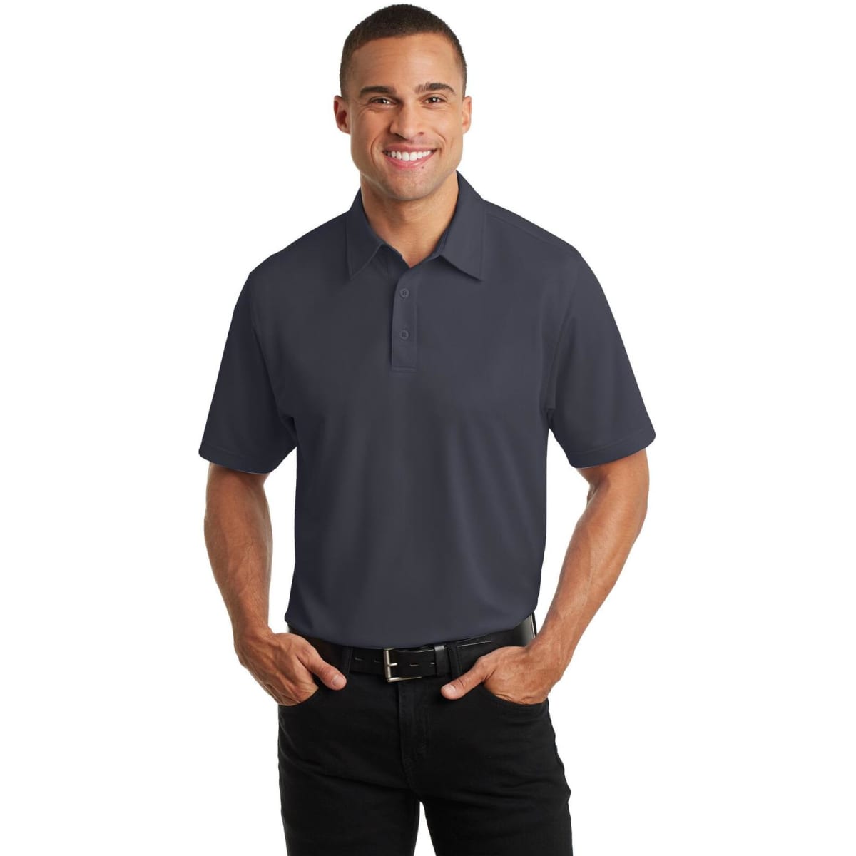 A man in a dark grey polo shirt with a collar, standing and smiling. The shirt features a logo.