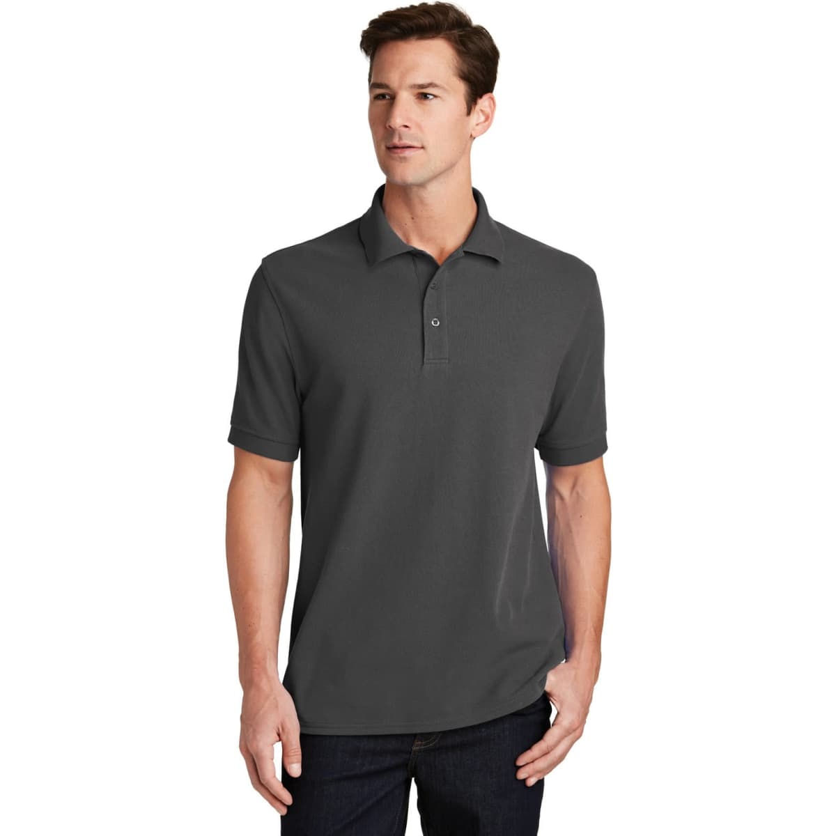 A man is wearing a dark grey Port & Company ring spun pique polo shirt. The shirt features a collar and buttons.