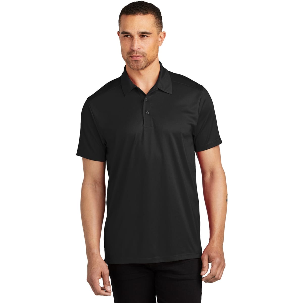 A man wearing a black polo shirt with a collar, featuring a logo on the chest.