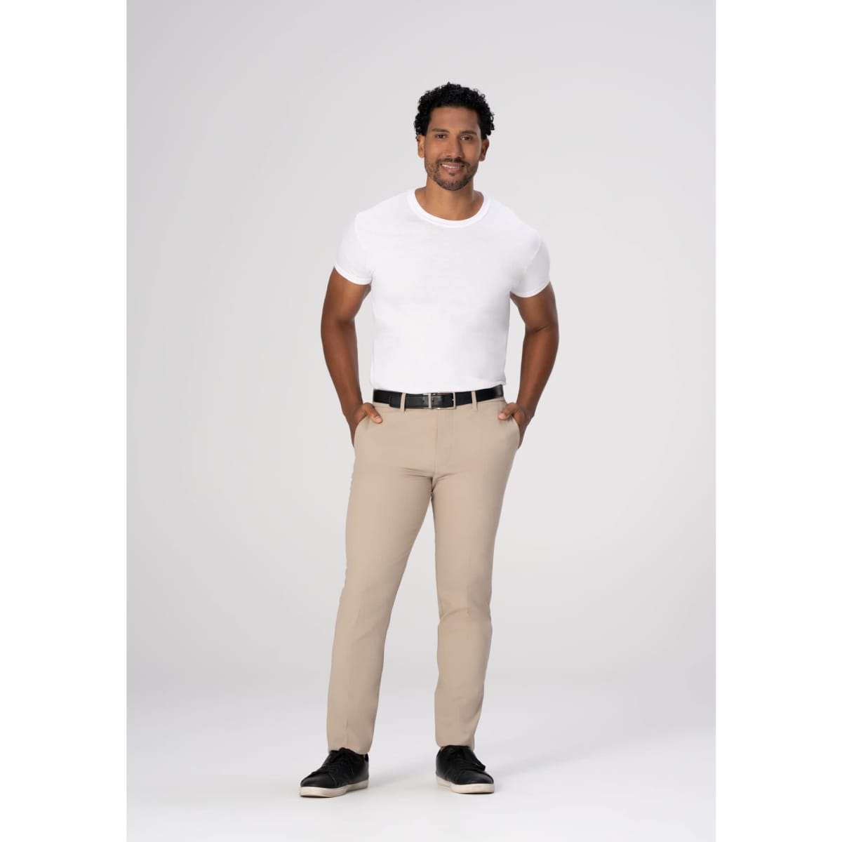 Chino men's poly stretch pants in beige, styled with a white t-shirt and black belt, model standing confidently.