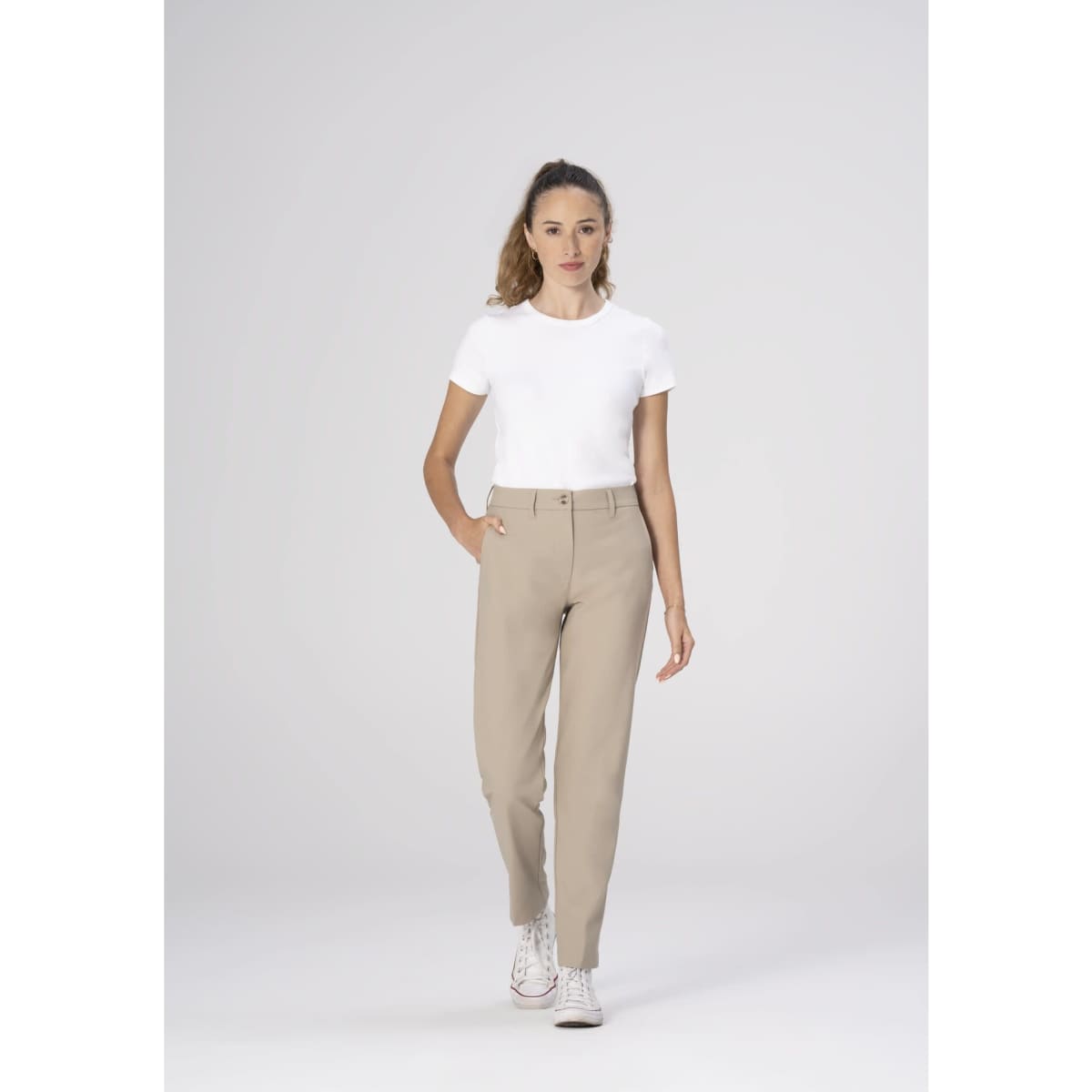 Chino women's poly stretch pants in beige, styled with a white t-shirt and white sneakers, displayed against a neutral background.