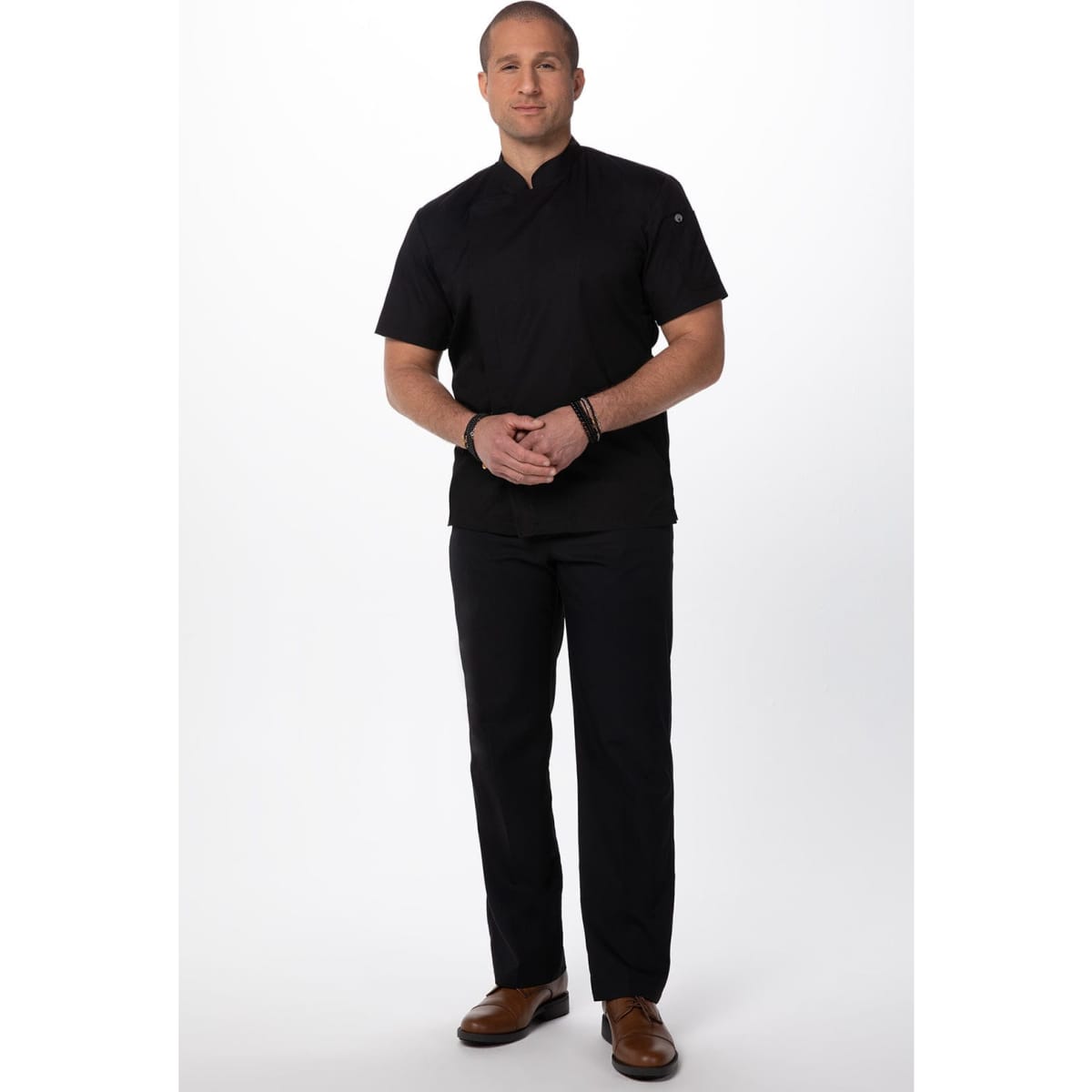 A chef jacket in black with short sleeves, paired with matching black pants and brown shoes. It features a logo.