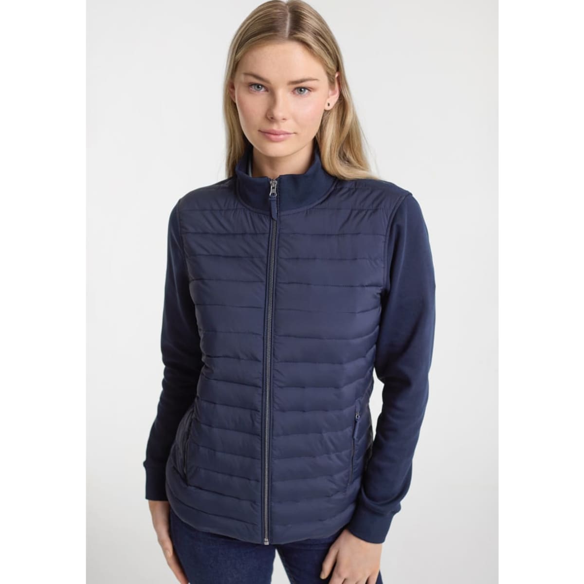 A women's tailor jacket in navy, featuring a zip front and a combination of padded and smooth fabric.